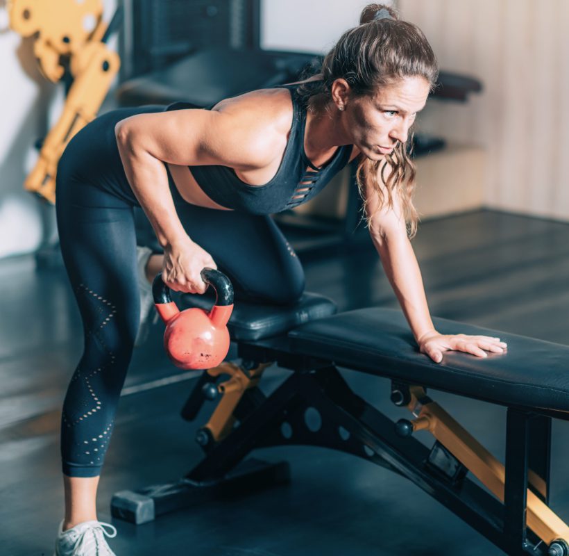 Female Athlete Exercising with Kettlebell.